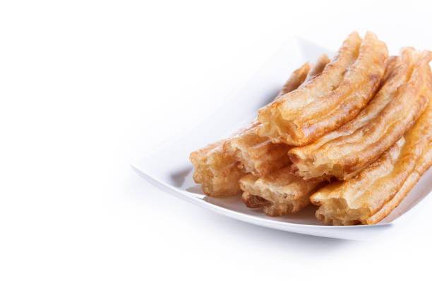 Heap of spanish churros stuffed with custard cream , spanish traditional sweet food. Close-up vertical view. Chocolate wrapped churros in the background. Copy space available.