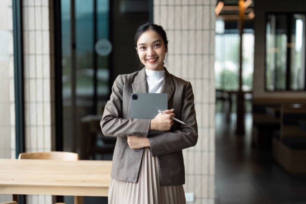 istock Confident Young Professional Woman Holding Tablet in Modern Office Setting with Natural Light 2188338976