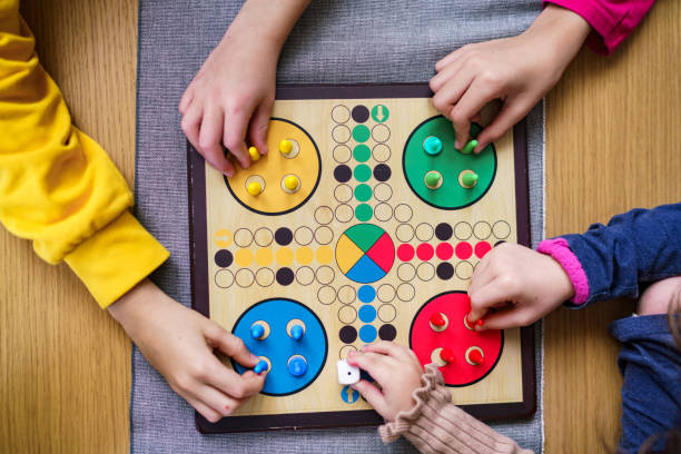 Children's hands are preparing for the Ludo game stock photo