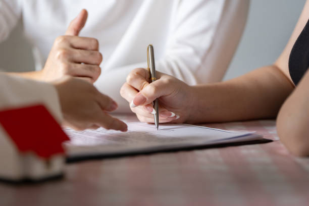 istock Real Estate Transaction: Signing Documents for Property Purchase with Professional Guidance 2188340119
