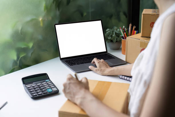 istock Modern Startup SME Small Business Entrepreneur Working on Laptop with Packaging Boxes and Calculator on Desk 2188340515