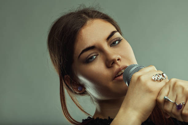 istock Young woman singer performing with microphone in studio 2188340569