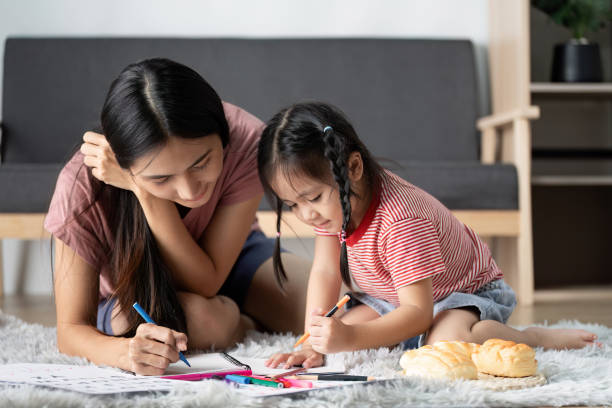 istock Mother and Child Engaged in Creative Learning Activities at Home on a Cozy Carpeted Floor 2188340683
