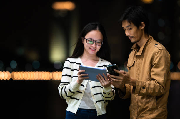 istock Asian Couple daily using electronic device tablet and smartphone sharing information stock photo 2188344981