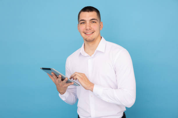 istock Motivated young man reviewing documents on a tablet 2188345343