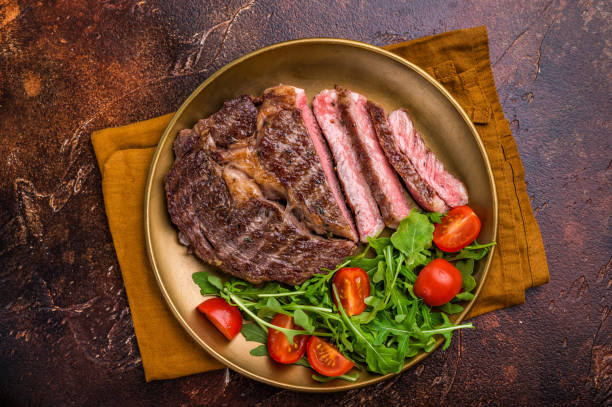istock Dinner with Grilled Rib eye steak, fried dry aged beef meat. brown background. top view 2188346469