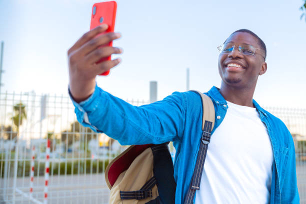 istock Young man taking a selfie while holding a yellow folder outdoors with glasses 2188347376