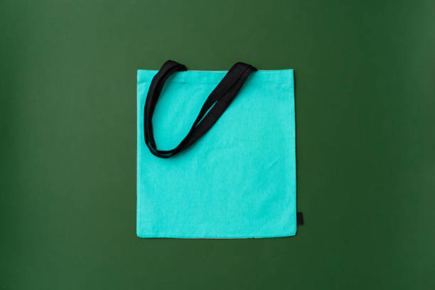 istock Textile shopping bag on green background flat lay 2188349217