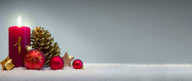istock First Advent candle with red Christmas decoration. 2188349893