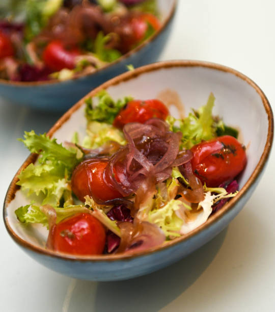 istock Salad with cherry tomatoes, onions and lettuce in a blue bowl 2188350137