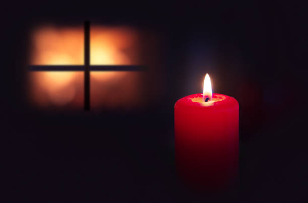 A burning candle and the window late at night. Lighting a candle on night. Family time.