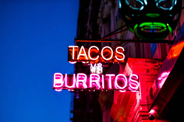 istock Vibrant Neon Sign Featuring a Playful Tacos vs Burritos Theme Glows Brightly Against a Deep Blue Night Sky in an Urban Setting 2188354163