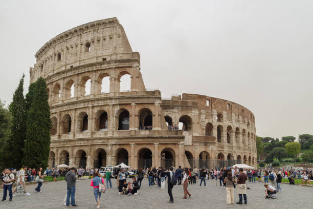 Rome, Italy - October 16, 2024: People stroll past the Colosseum monument in Rome