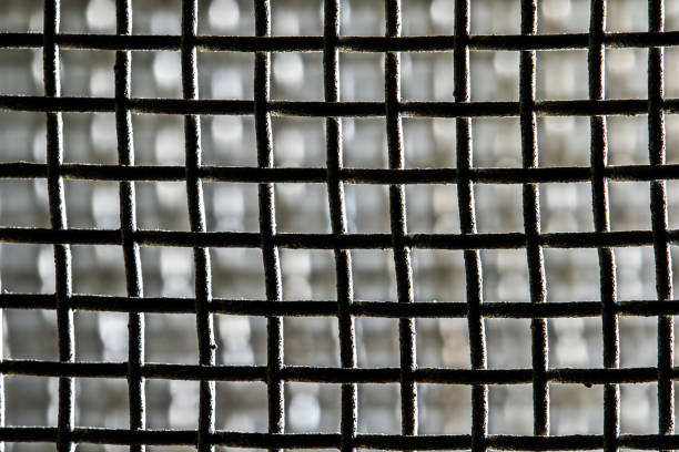 Metal grid forming a repetitive pattern with a blurred background