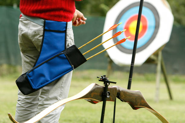 istock Archer wearing quiver and holding arrows is aiming at target 2188356066