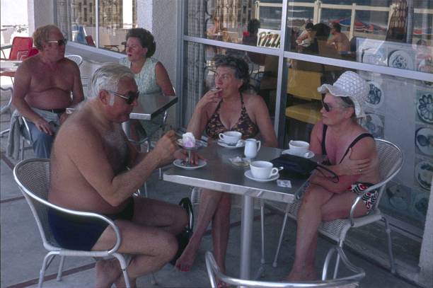 Mallorca, Catalonia, Spain, 1973. Holidaymakers from Central Europe taking a shady coffee break on a beach bodega terrace.