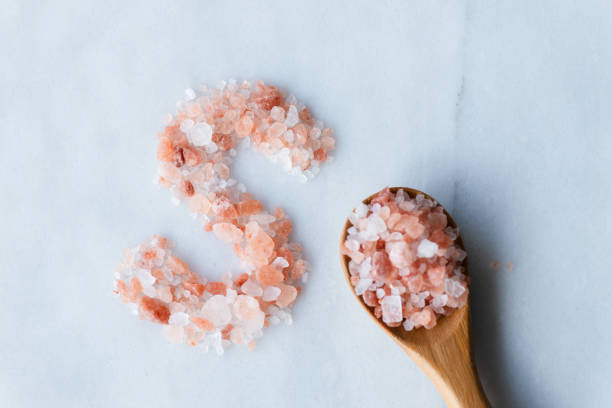 A minimalist arrangement of Himalayan pink salt granules forming the letter \