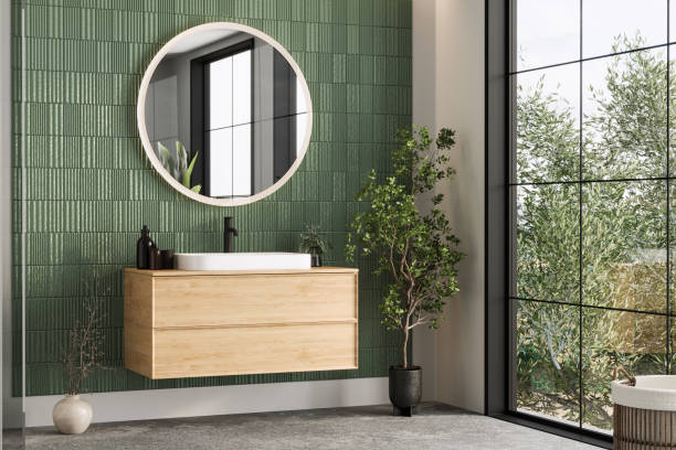 istock Minimalist bathroom with green ceramic wall tiles, a wooden vanity, and ample natural light, creating a simple yet sophisticated design. 2188360008