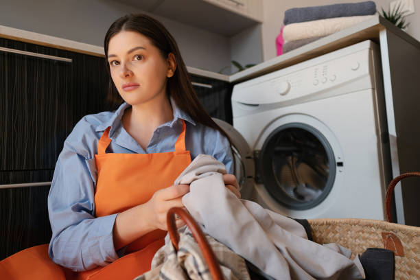 istock A woman sorts laundry for washing, using detergent for delicate fabrics, caring for silk and wool garments. 2188360058