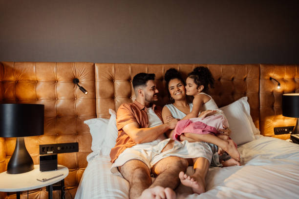 istock Couple playing with daughter on hotel bed 2188360287
