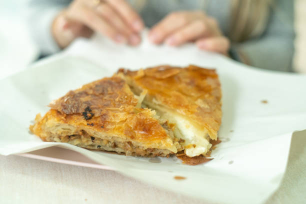 istock Woman hands eating Borek closeup 2188365206