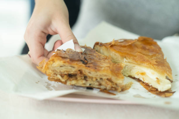 istock Woman hands eating Borek closeup 2188365209