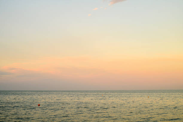 A pastel-colored sunset over a calm sea, reflecting serene beauty and the tranquility of nature.