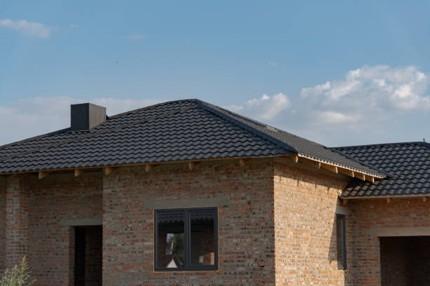 This residential home features a contemporary rooftop with stylish metallic tiles that enhance its elegant architecture. The structure stands proudly against a clear blue sky, embodying modernity