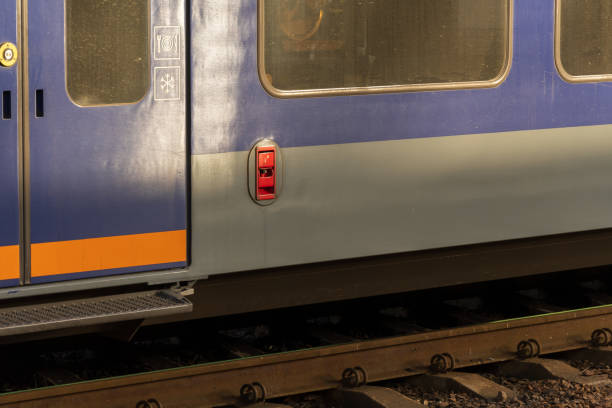 istock Brightly colored electric train stands at the platform, showcasing industrial design elements while passengers eagerly wait to board for their daily commute 2188370217