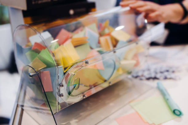 Process of prize drawings, extracting a winning numbers of lottery machine, raffle drum with a bingo balls, bingo machine and winning tickets on event with a female host, hands on lottery machine stock photo