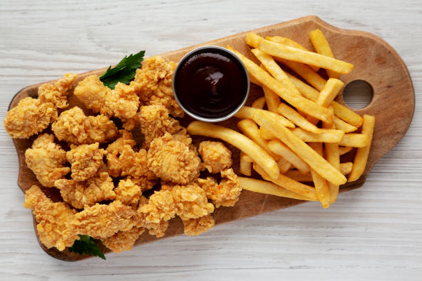 istock Homemade Popcorn Chicken with BBQ Sauce on a Rustic Wooden Board, top view. Flat lay, overhead, from above. 2188377585