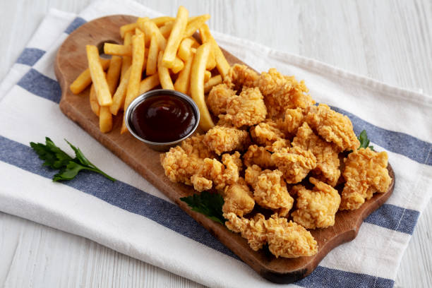 istock Homemade Popcorn Chicken with BBQ Sauce on a Rustic Wooden Board, side view. 2188377800