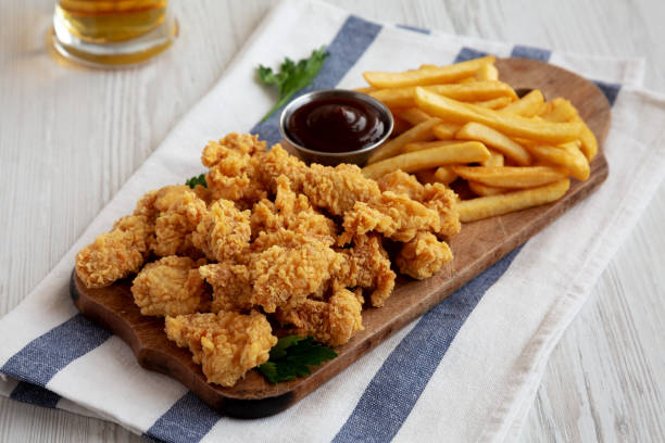 istock Homemade Popcorn Chicken with BBQ Sauce on a Rustic Wooden Board, side view. 2188377899