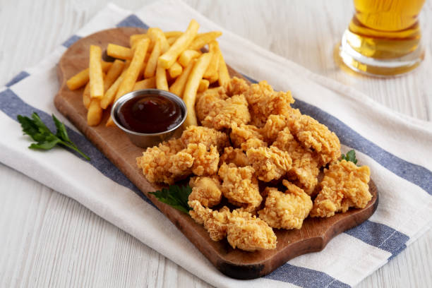 istock Homemade Popcorn Chicken with BBQ Sauce on a Rustic Wooden Board, side view. 2188377929