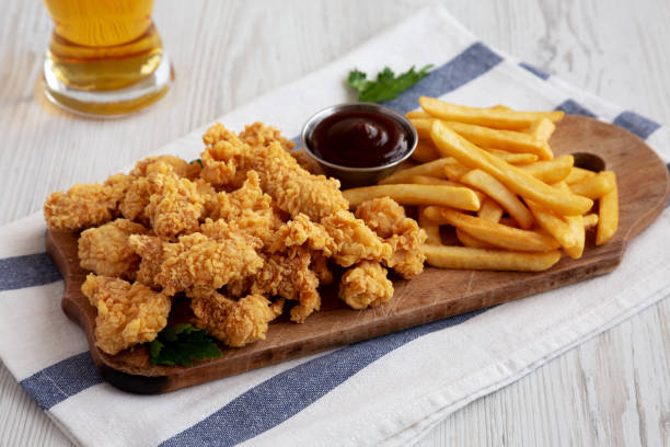 istock Homemade Popcorn Chicken with BBQ Sauce on a Rustic Wooden Board, low angle view. 2188377998