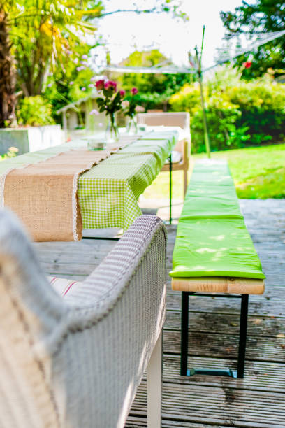 istock Elegant Outdoor Dining Setup with Rustic Tablecloth and Vibrant Floral Decorations in a Sunlit Garden, Perfect for a Relaxed Summer Gathering or Alfresco Lunch 2188381074