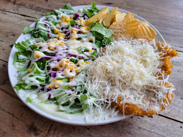 Tasty Chicken Schnitzel With Crispy Fried Breast Chicken Meat, Potato Wedge, Potato Chips, Lettuce, Sliced Onion, Lettuce, Boiled Corn Kernel Seed, Eggplant, Grated Cheese And Mayonnaise Sauce. Western Food Menu.