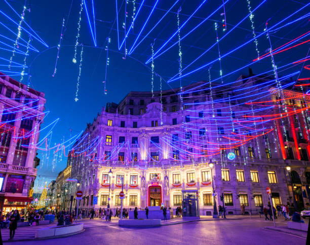 Madrid, Spain - December 4, 2024. Plaza de Canalejas Square illuminated by christmas lights at nightfall, with Galerias Canalejas Mall in the background. Madrid, Spain.