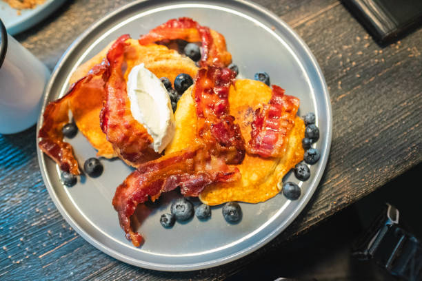 istock Breakfast Plate Featuring Crispy Bacon, Fluffy Pancakes, Fresh Blueberries, And Cream Cheese For A Morning Meal. A Tantalizing Arrangement That Invites You To Savor Every Bite On A Rustic Table 2188386985