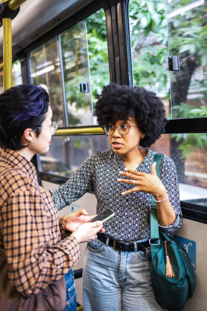 istock Two young women engaging in conversation during a city bus ride 2188387753