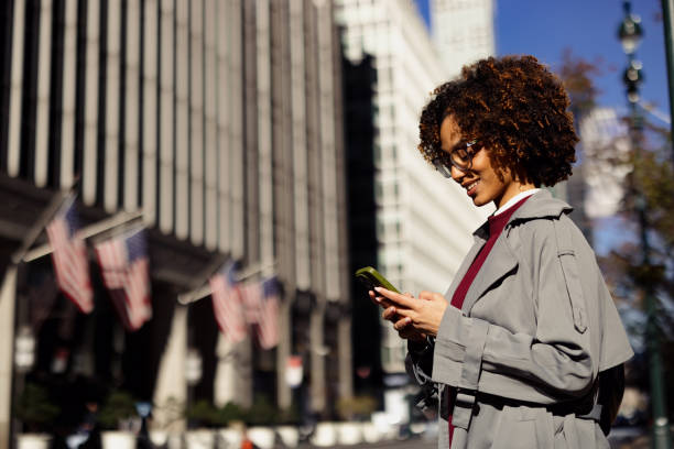 istock Business Woman Using Smartphone While Walking Through New York City 2188388533