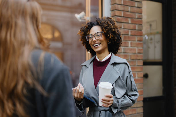 istock Smiling Businesswoman With Coffee Conversing Outdoors in Urban Setting 2188388541