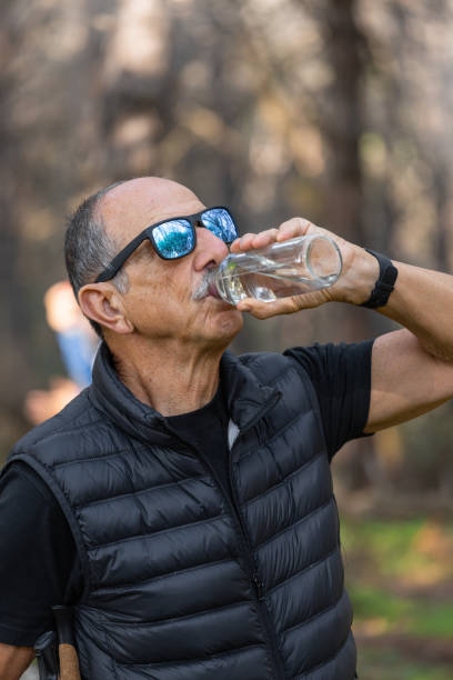 istock A man enjoys hydrating outdoors, surrounded by natures beauty and peaceful tranquility 2188388968