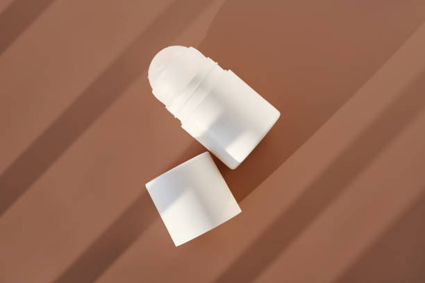 istock Roll-on deodorant on a purple background with shadow stripes. 2188389220