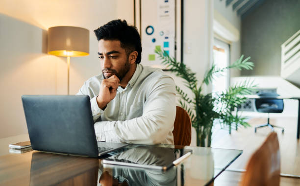 istock Young Man Focused on Laptop Screen at Desk 2188392564