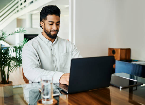 istock Happy Young Man Working on Laptop at Desk 2188392569