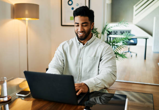 istock Happy Young Man Working on Laptop at Desk 2188392572
