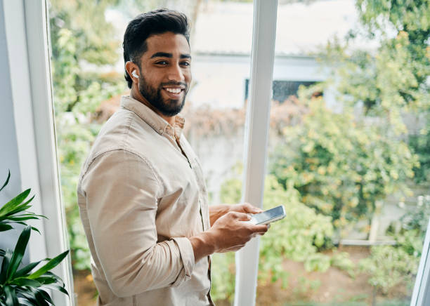 istock Young Man Holding Smartphone and Smiling at Camera 2188392595