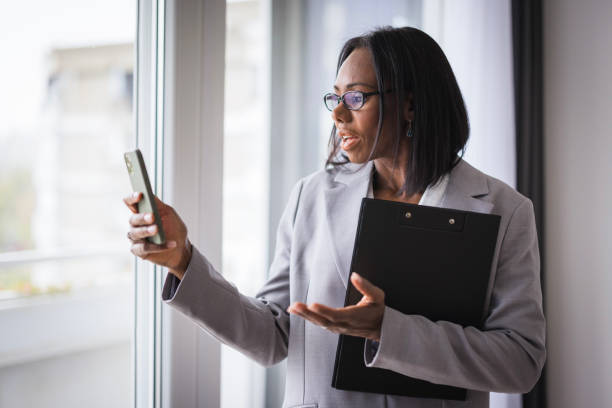 istock Nervous business woman holding documents and using phone 2188393405