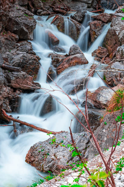 istock Tranquil Mountain Stream Cascading Over Rocks With Lush Greenery 2188393485
